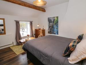 a bedroom with a bed and a desk and a window at Carr House Farm in Glossop