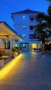 un grand bâtiment blanc avec une cour la nuit dans l'établissement Bali Luxury Apartments Diani, à Ukunda