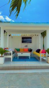 - un salon avec des canapés et des tables sur une terrasse dans l'établissement Bali Luxury Apartments Diani, à Ukunda