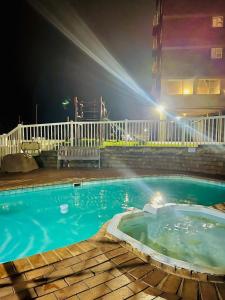 a swimming pool at night with lights on a building at Beach View in Scottburgh