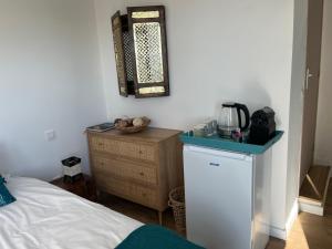 Schlafzimmer mit einem Bett, einer Kommode und einem Spiegel in der Unterkunft Villa Héliopolis in Ventiseri