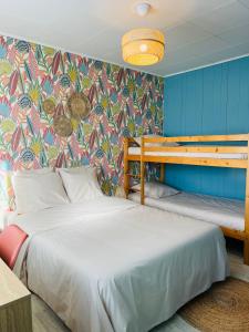 a bedroom with two beds and a colorful wall at Motel Les Broussailles in Mesves-sur-Loire