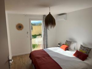 ein Schlafzimmer mit einem Bett und einem großen Fenster in der Unterkunft Villa Héliopolis in Ventiseri