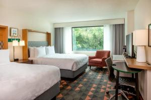 a hotel room with two beds and a desk at Holiday Inn Newport News - Hampton, an IHG Hotel in Newport News