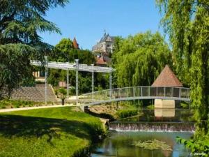 un pont sur une rivière dans un parc dans l'établissement Maison de 4 chambres avec jardin clos et wifi a Saint Florentin, à Saint-Florentin