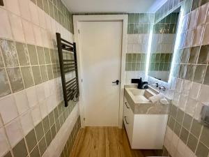 a bathroom with a sink and a white door at Apartamento Moderno con gran terraza" GREGAL" in Port de Soller