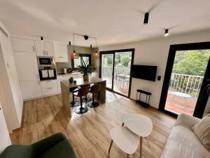 uma cozinha e sala de estar com uma mesa e um sofá em Apartamento Moderno con gran terraza" GREGAL" em Port de Sóller