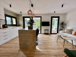 a kitchen and living room with a couch and a table at Apartamento Moderno con gran terraza" GREGAL" in Port de Soller +15 photos