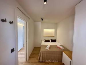 um quarto com uma cama num quarto branco em Apartamento Moderno con gran terraza" GREGAL" em Port de Sóller