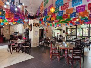 um restaurante com mesas e cadeiras e decorações coloridas em HOSTAL HACIENDA APULCO 