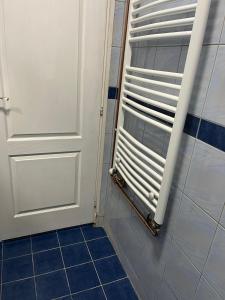 a bathroom with a door and a tile floor at Apartmani Vrabac 4 in Divčibare