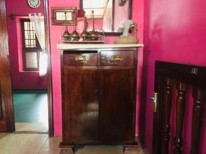 a bathroom with a wooden cabinet in a pink wall at NICE APARTMENT in Kituoni