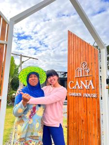 een man en een vrouw die voor een bord staan bij Cana​ Garden​ House​ โฮมสเตย์​ in Ban Khok