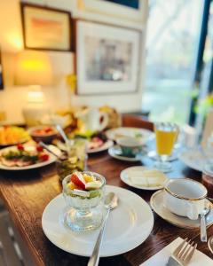 una mesa de madera cubierta con platos y tazones de comida en Przechowalnia Marzeń- Adults Only, en Mikołajki