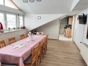 a dining room with a pink table and chairs at Villa Real Paradise in Smižany