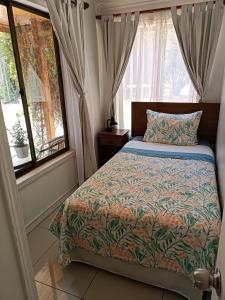 サン・ホセ・デ・マイポにあるCabaña El Tiempo Es Arteのベッドルーム(ベッド1台、窓付)