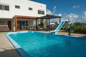 a swimming pool with a slide and a playground at Casa Espetacular na Praia de Graçandu by Carpediem in Extremóz