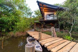una casa con muelle y un barco en el agua en Recanto Ecológico en São Gabriel