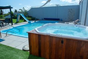 una vasca idromassaggio in un cortile accanto alla piscina di Casa Espetacular na Praia de Graçandu by Carpediem a Contenda