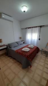 een slaapkamer met een groot bed en 2 handdoeken bij Apart Begonia, 1 dor con patio de luz in Río Cuarto