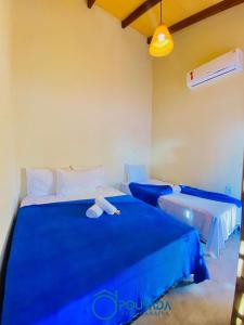 - une chambre avec un lit bleu et une baignoire dans l'établissement Pousada Alta Caraíva, à Caraíva