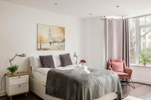 - un salon blanc avec un lit et une chaise dans l'établissement 6-bedroom LUX House next to Hyde Park &Marble Arch, à Londres