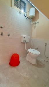 baño con aseo y taburete rojo en Shree Narayan Home Stay, en Ayodhya