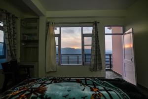 een slaapkamer met een bed en een groot raam bij Mom Blessing Homestay in Shimla