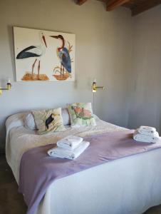 1 dormitorio con 1 cama con toallas en La pacaa` en Bella Vista