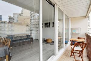 a balcony with sliding glass doors and a table at Large family T3 with parking near La Défense in Nanterre