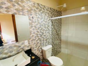 La salle de bains est pourvue de toilettes, d'un lavabo et d'une douche. dans l'établissement Pousada Alta Caraíva, à Caraíva