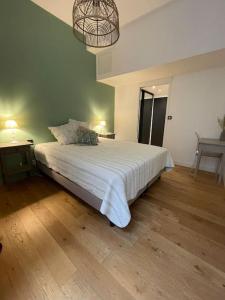 a bedroom with a bed with a white comforter at Cosy Fourbastard in Toulouse