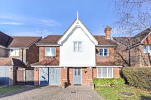 a house with a white front door and brick houses at The Woodlands, shortstay, ideal for families, relocation, contractors, travel stay in Horley