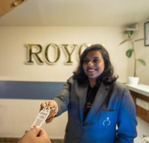een vrouw met een afstandsbediening in een kamer bij Hotel Royce Executive Near US Consulate, Bandra Kurla Complex in Mumbai