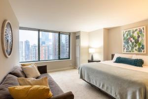 a bedroom with a large bed and a couch at Captivating Apartment with Pier Views, Pool and Gym in Chicago