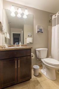 a bathroom with a toilet and a sink and a mirror at Captivating Apartment with Pier Views, Pool and Gym in Chicago