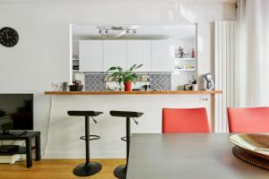 kuchnia z czerwonymi krzesłami i stołem w obiekcie Appartement design pour les amateurs de modernité w Paryżu