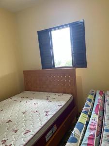 um pequeno quarto com uma cama e uma janela em Chácara Vista para Represa em Mogi das Cruzes