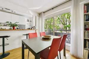 jadalnia ze stołem i krzesłami oraz oknem w obiekcie Appartement design pour les amateurs de modernité w Paryżu