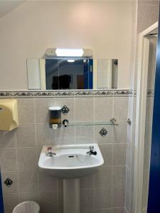a bathroom with a sink and a mirror at Coastguard Lodge Hostel at Tigh TP in Dingle