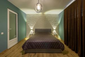 a bedroom with a bed and a brick wall at Студія Terrasa in Chernivtsi