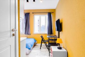 Schlafzimmer mit gelben Wänden, einem Bett und einem Schreibtisch in der Unterkunft Furnished Studio Flat 5 min to Coast in Fatih in Istanbul