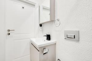 W białej łazience znajduje się umywalka i lustro. w obiekcie Furnished Studio Flat 5 min to Coast in Fatih w Stambule