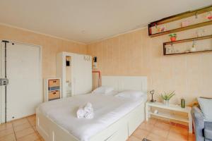 Un dormitorio con una cama blanca con toallas. en Elegant apartment in Le Pré-Saint-Gervais, en Le Pré-Saint-Gervais