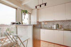 cocina con armarios blancos y balcón en Elegant apartment in Le Pré-Saint-Gervais, en Le Pré-Saint-Gervais