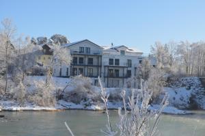 a building next to a river with snow at "Riverside" in Prem