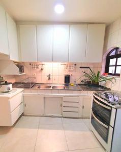 a kitchen with white cabinets and a sink at Casa 146 - SP Expo, Metrô, Congonhas in Sao Paulo