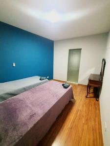 um quarto com uma cama e piso em madeira em Casa 146 - SP Expo, Metrô, Congonhas em São Paulo