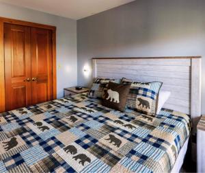 a bedroom with a bed with a quilt and pillows at Allegheny241Hot/Tub/Pool,Ski In/Out,Village in Snowshoe +39 photos