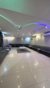 uma grande sala com sofás, mesas e luzes em استراحة وشاليه وقاعة السلطانه رجال em Al-Salam
